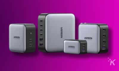 A UGREEN USB-C charger is powering a smartphone, a portable communication device, and other electronic gadgets.