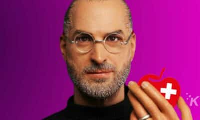 Steve Jobs holds a red apple logo