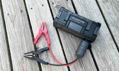 A tool is connecting a cable to an outdoor AVAPOW 12V 6000A.