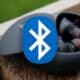 bluetooth logo with blurred earbuds in the background