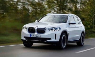 The white BMW iX3 suv electric is driving on the road.