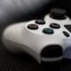 sony playstation 4 white controller and console in the background apple tv