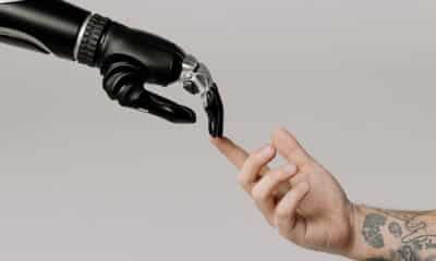 A robot hand is touching a human hand.