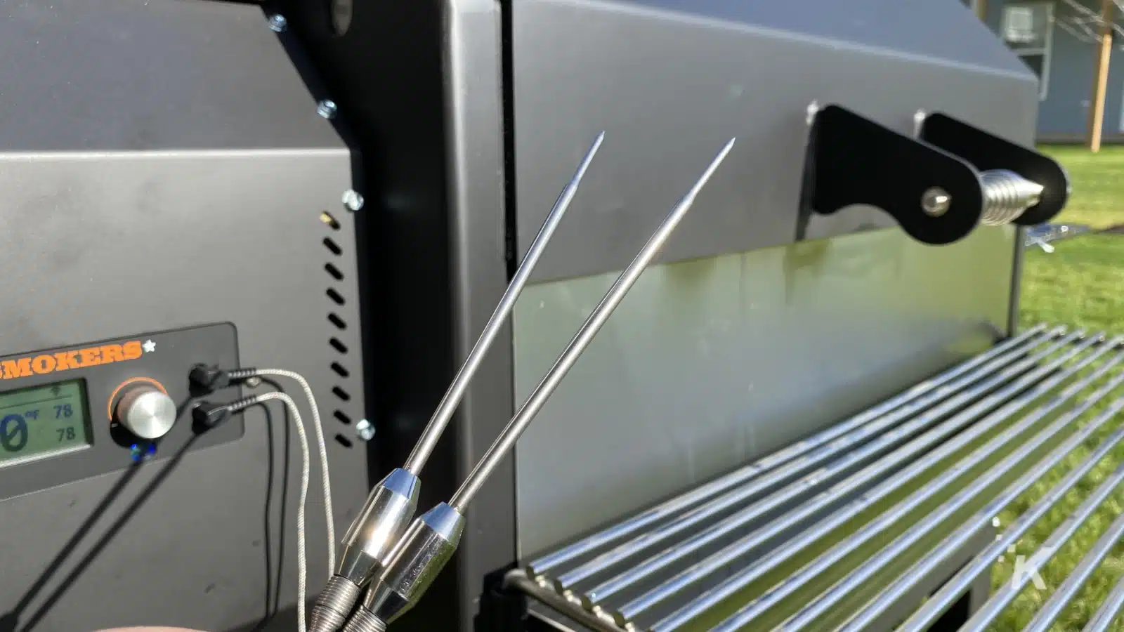 two temperature probes in front of a yoder pellet grill
